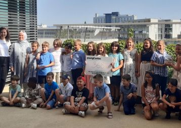 Eine Gruppe von Kindern von youngCaritas posiert mit einem Schild, das eine Spendenhöhe von 368 anzeigt; eine Feier des Engagements.