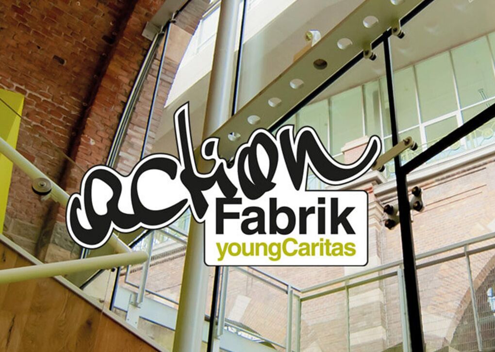 Logo von Aktion Fabrik - youngCaritas vor einer modernen, hellen Architektur mit Fenstern und Holzstufen.