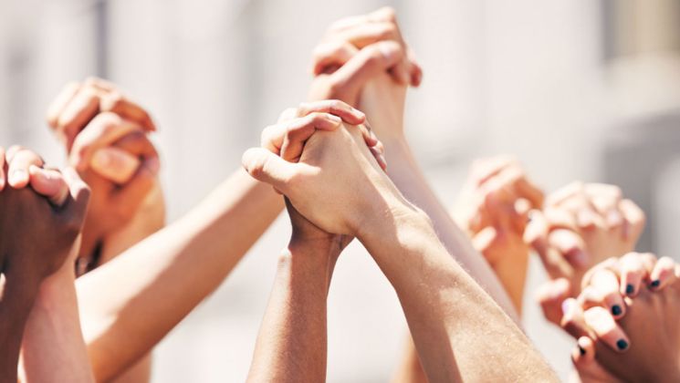 Eine Vielzahl von Händen, die sich vereinen, symbolisieren Gemeinschaft und Solidarität.