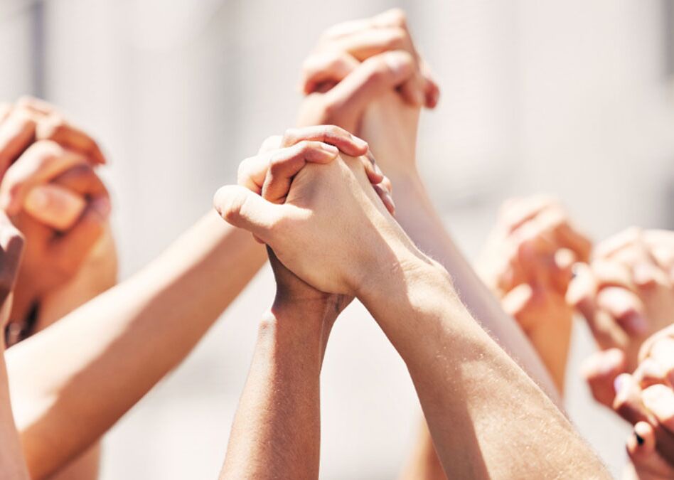 Eine Vielzahl von Händen, die sich vereinen, symbolisieren Gemeinschaft und Solidarität.