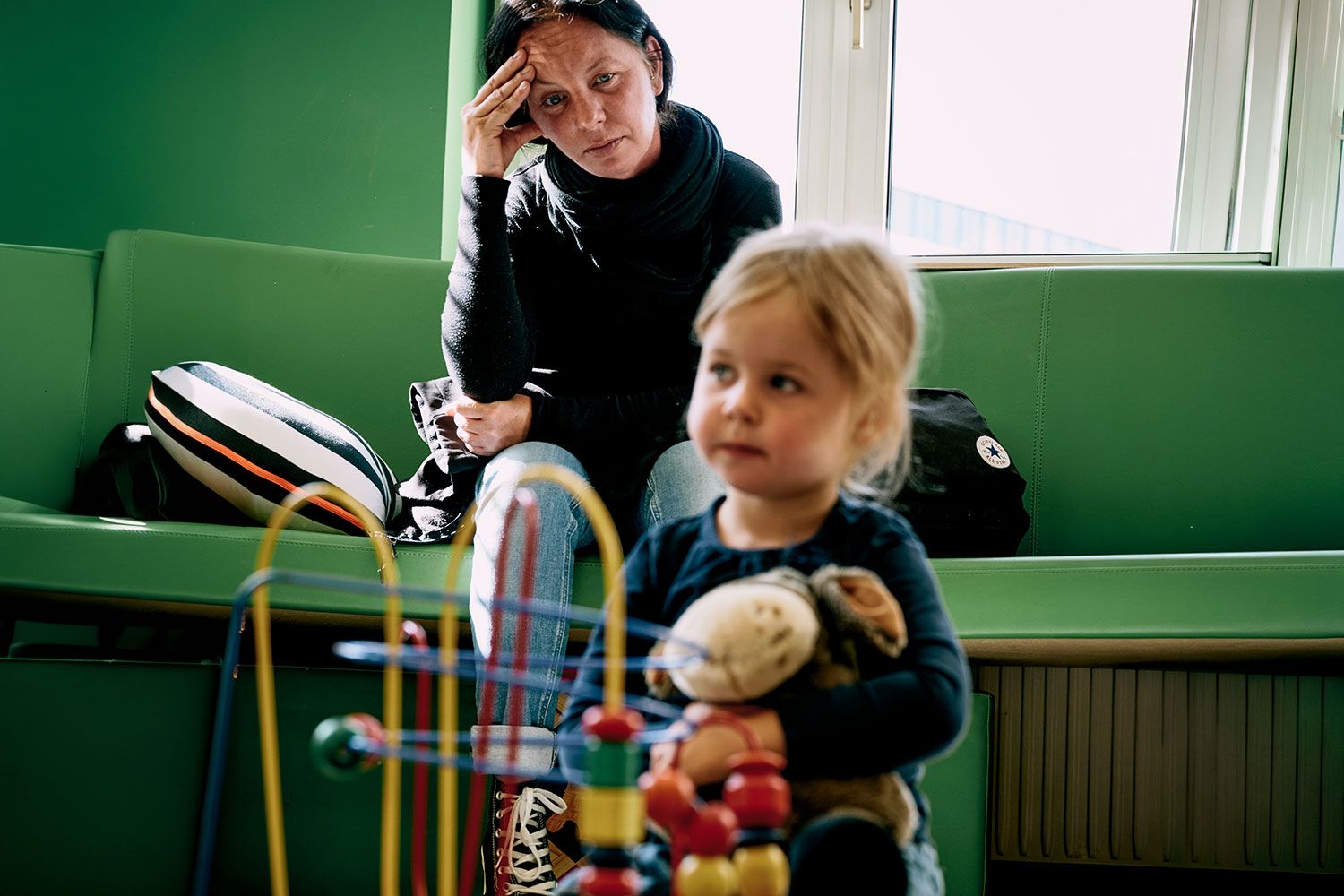 Seelisch belastete Frau beobachtet ihr Kind beim Spielen