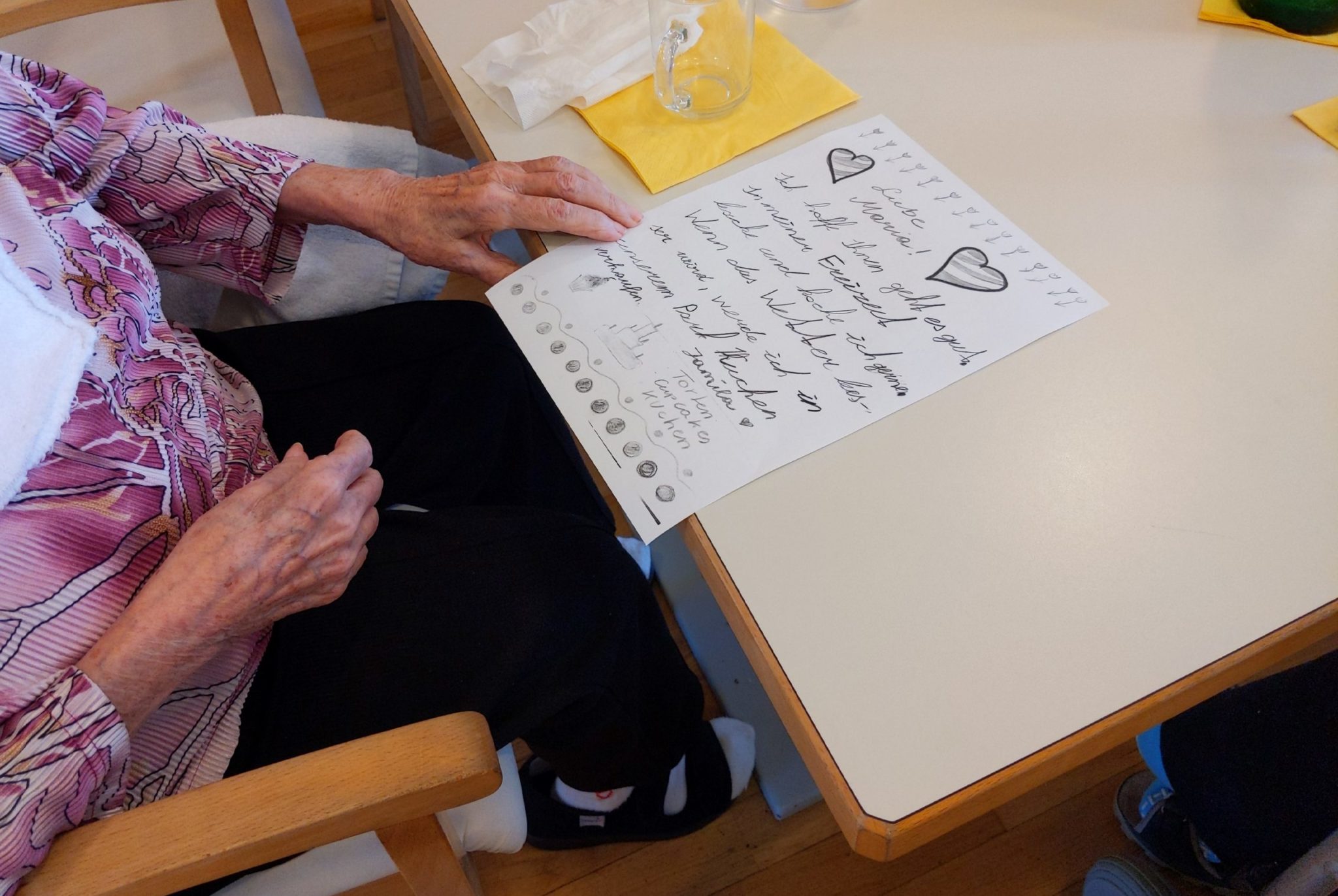 Eine Seniorin liest einen Brief, den sie von eine Teilnehmer*in an der Briefaktion erhalten hat.