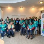 Gruppe von Schüler*innen, Caritas Mitarbeiter*innen und anderen Menschen lächeln in die Kamera, sie tragen Tshirts mit der Aufschrift "Pack Mas an!"